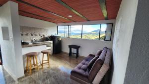 a living room with two chairs and a kitchen at Carpe Diem in Guatavita