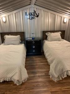 a bedroom with two beds with white sheets and a wooden floor at Lobo Lake Cabin in Cisco