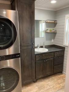 uma cozinha com um lavatório e uma máquina de lavar roupa em Lobo Lake Cabin em Cisco