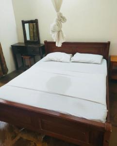 un dormitorio con una cama con sábanas blancas en Sea Breeze Apartments Shanzu Mombasa, en Mombasa