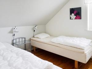 Duas camas num quarto com paredes brancas em Holiday home VISBY III em Visby