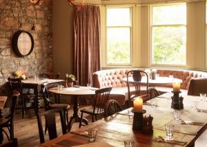 a restaurant with tables and chairs and a couch at Craigellachie Hotel of Speyside in Craigellachie