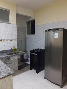 a kitchen with a stainless steel refrigerator and a sink at Casa da Deusa in Belém