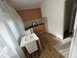 a small kitchen with a white table and chairs at Bubingaa in Kruševac