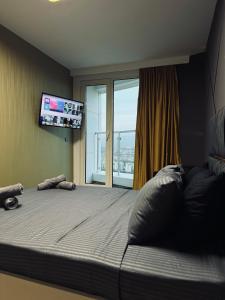 1 dormitorio con 1 cama grande y TV de pantalla plana en Royal Kate SPA included, 30th floor, en Skopje