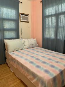Schlafzimmer mit einem großen Bett und blauen Vorhängen in der Unterkunft Duran Pool & Guesthouse in Sison