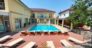 a swimming pool with lounge chairs and a house at Hotel ERA in Pristina