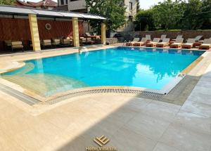 a large blue swimming pool with chairs on a patio at Hotel ERA in Pristina
