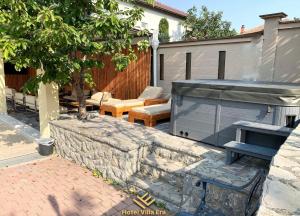 eine Terrasse mit einem Grill, einem Tisch und Stühlen in der Unterkunft Hotel ERA in Pristina