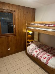 een slaapkamer met 2 stapelbedden en een klein bed bij Appartement aux portes de Megeve in Praz-sur-Arly