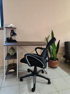 a desk with a black chair in a room at Downtown Apartment One Block from the Ocean - Casa Aluxes in Cozumel