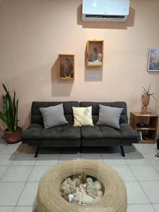 a living room with a black couch and a basket at Downtown Apartment One Block from the Ocean - Casa Aluxes in Cozumel