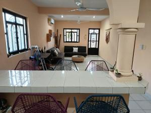 a kitchen and living room with a table and chairs at Downtown Apartment One Block from the Ocean - Casa Aluxes in Cozumel