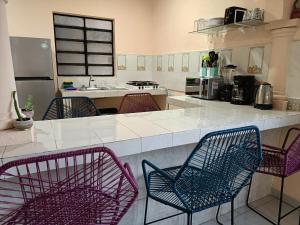 uma cozinha com quatro cadeiras e uma bancada em Downtown Apartment One Block from the Ocean - Casa Aluxes em Cozumel