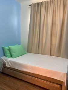 Bett in einem Zimmer mit einem Vorhang und einem Bett sidx sidx sidx sidx in der Unterkunft Duran Pool & Guesthouse in Sison