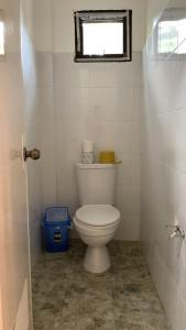 a white toilet in a bathroom with a window at Duran Pool & Guesthouse in Sison