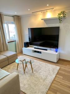 ein Wohnzimmer mit einem großen Flachbild-TV in der Unterkunft Lisbon Luxury Studio in Amadora