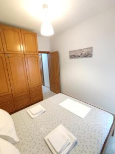 a room with a bed and wooden cabinets at Sea View Apartments Nikos in Nea Peramos