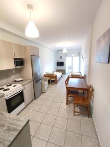 eine Küche mit einem Tisch und einem Esszimmer in der Unterkunft Sea View Apartments Nikos in Néa Péramos