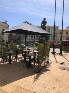 a patio with tables and an umbrella and a statue at Departamento con vista juegos artificiales Valparaíso in Valparaíso +13 photos