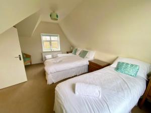 1 dormitorio en el ático con 2 camas y ventana en Stoke villas en Gosport
