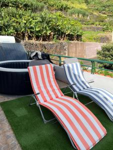 two lawn chairs sitting next to a fire hydrant at Pana House in Calheta