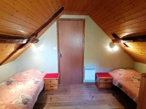 1 dormitorio con 2 camas y techo de madera en Lou cridadé en Laruns