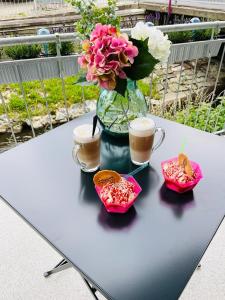 a table with two cups of coffee and a vase with flowers at schloss1 in Selb