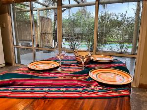 a table with plates and wine glasses on it at Botanico in Villa Elisa