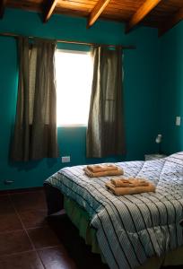 a bedroom with a bed with two towels on it at Casa Yaoyín in El Chalten