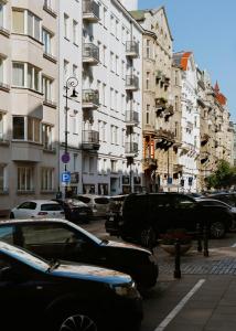 een stadsstraat met auto's geparkeerd voor hoge gebouwen bij City Garage Apartment - Lwowska 9 in Warschau