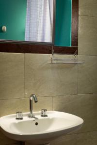 Casa Yaoyín في إل تشالتين: بالوعة بيضاء في الحمام مع مرآة