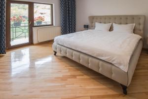 1 cama grande en un dormitorio con suelo de madera en CASA SPERANTA, en Cugir