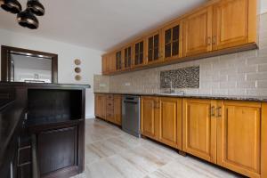 una cocina con armarios de madera y electrodomésticos negros en CASA SPERANTA, en Cugir