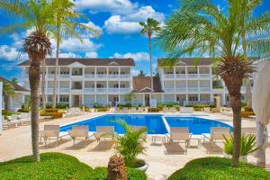 un complejo con piscina y palmeras en Hoteles Josefina Las Terrenas, en Las Terrenas
