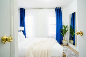 ein weißes Schlafzimmer mit blauen Vorhängen und einem Bett in der Unterkunft 1435-4 I 3 Bedrooms 2Bath W D Prime Upper east in New York