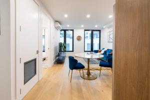een woonkamer met een tafel en blauwe stoelen bij 149BK-202 NEW Condo 1BR IN PRIME GREENPOINT BK in Brooklyn