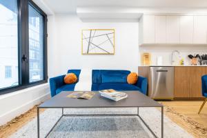 a living room with a blue couch and a table at 149BK-202 NEW Condo 1BR IN PRIME GREENPOINT BK in Brooklyn
