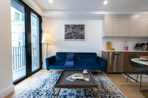 uma sala de estar com um sofá azul e uma mesa em 149BK-302 New Construction 1BR WD in unit Balcony em Brooklyn