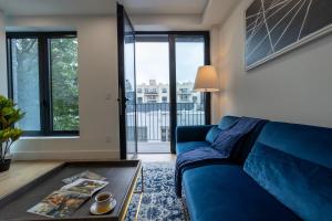 a living room with a blue couch and large windows at 149BK-302 New Construction 1BR WD in unit Balcony in Brooklyn