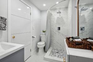 La salle de bains blanche est pourvue de toilettes et d'un lavabo. dans l'établissement Amalfi Cottage - 1 1 Tropical Paradise in Grove, à Miami