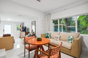 a living room with a couch and a table at Amalfi Cottage - 1 1 Tropical Paradise in Grove in Miami