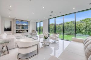 a living room with white furniture and large windows at Exquisite Hamptons Mansion Retreat in Water Mill