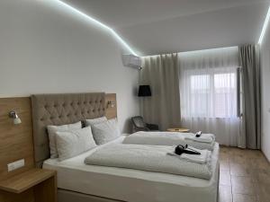 um quarto com uma grande cama branca e uma janela em Evita Apartmani Šibovska em Prnjavor