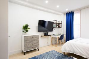 a bedroom with a bed and a tv on a wall at 1597-12 NEW Studio Prime UES WD in unit in New York