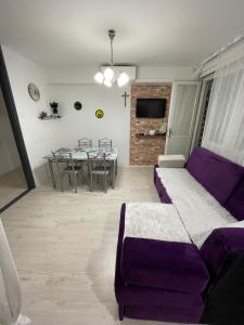 sala de estar con sofá púrpura y mesa en Ivan en Široki Brijeg