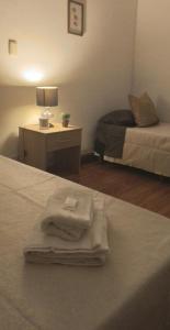 um quarto de hotel com uma cama com toalhas em La Casa de las Flores em Salta
