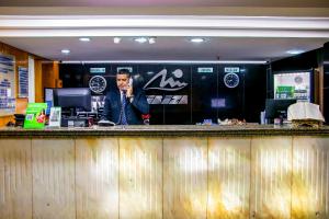 un hombre hablando por celular en un bar en Hotel Nacional Inn Rio Copacabana, en Río de Janeiro