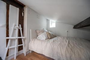 Habitación blanca con cama y escalera en Beautiful duplex on the outskirts of Paris - Welkeys, en Levallois-Perret