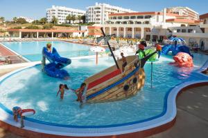 a swimming pool with two people in it at Be Live Family Palmeiras Village All-Inclusive 24H in Armação de Pêra